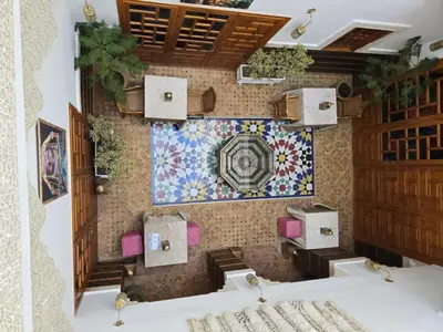 a room with a tile wall with a table and chairs at Riad Sidi in Fès