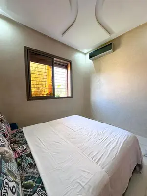a bedroom with a large white bed with a window at Villa Ghaith in Douar Tounsi