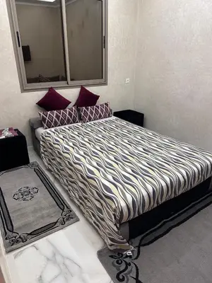 a bedroom with a large bed with purple pillows at Villa Ghaith in Douar Tounsi