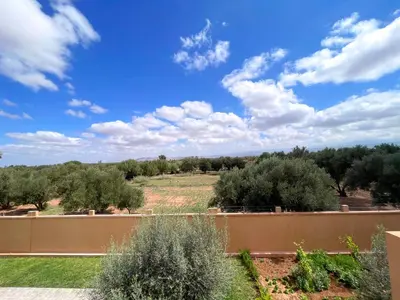 a view from the backyard of a house with a fence and trees at Villa Ghaith in Douar Tounsi