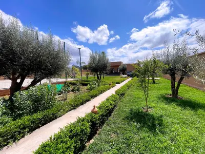 a garden with trees and a path at Villa Ghaith in Douar Tounsi