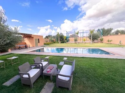 a yard with chairs and a swimming pool at Villa Ghaith in Douar Tounsi