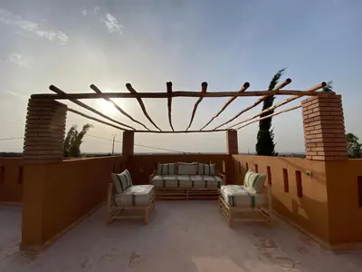 a patio with a couch and chairs on a roof at Dar Mazaheer in Ouanina