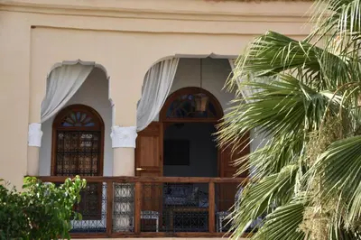 a house with a wooden door and a palm tree at Chambres Émeraude et Rubis - Riad Lotus Bleu in Fès
