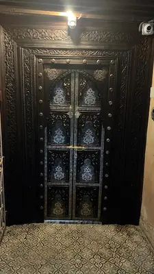 a wooden door with a lot of plates on it at Chambres Émeraude et Rubis - Riad Lotus Bleu in Fès