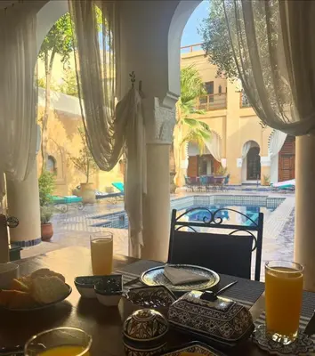 a table with food on it with a view of a building at Chambres Émeraude et Rubis - Riad Lotus Bleu in Fès