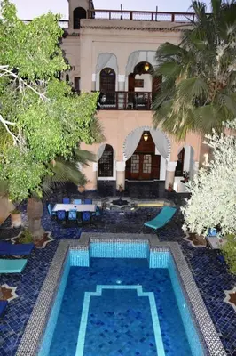 a large swimming pool in front of a building at Chambres Émeraude et Rubis - Riad Lotus Bleu in Fès