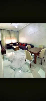 a living room with a table and chairs and a couch at Alia in Fès