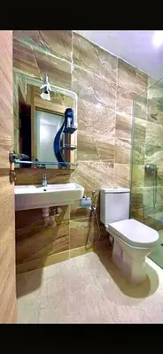 a bathroom with a toilet and a sink and a mirror at Alia in Fès