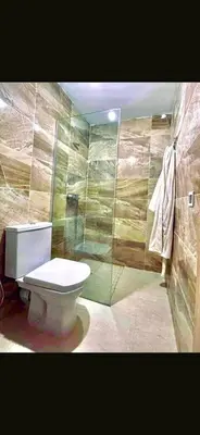 a bathroom with a toilet and a glass shower at Alia in Fès