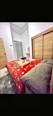 a bedroom with a bed with a red blanket on it at Alia in Fès