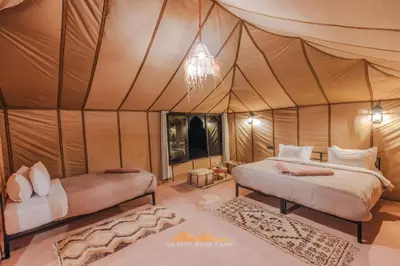 a bedroom with two beds in a tent at Desert Rose Camp in Merzouga