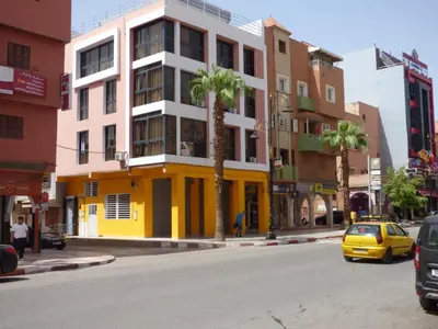 a yellow car parked on a city street with buildings at Diyafat Ghandi in Khenifra