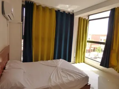 a bedroom with a bed with yellow and blue curtains at Diyafat Ghandi in Khenifra