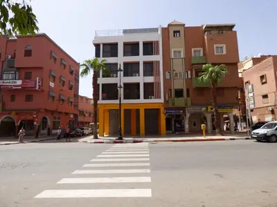 a street with a crosswalk in a city with buildings at Diyafat Ghandi in Khenifra