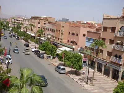 a city street with cars driving down a street with buildings at Diyafat Ghandi in Khenifra