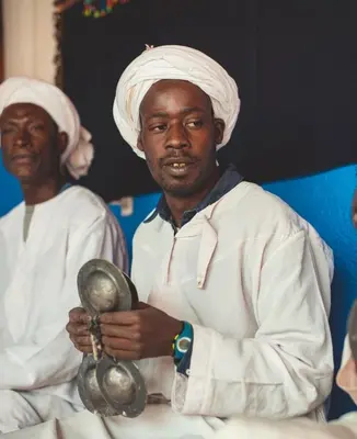 two men in white uniforms holding a instrument at Riad Dar Menorca in Merzouga