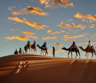 a group of people riding horses in the desert at Riad Dar Menorca in Merzouga