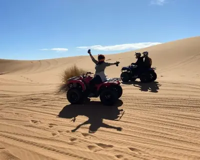 two people riding on atvs in the desert at Riad Dar Menorca in Merzouga