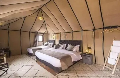 a bedroom with two beds in a tent at discover luxury camp in Merzouga