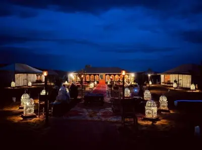 a group of chairs and lights at night at discover luxury camp in Merzouga
