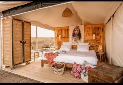 a bedroom with a bed in a tent at Lunaluxurycamp in Merzouga