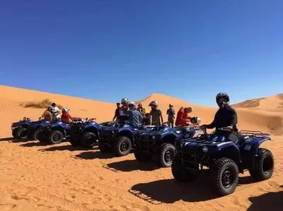a group of people riding atvs in the desert at Lunaluxurycamp in Merzouga