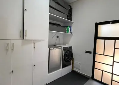a kitchen with white cabinets and a washing machine at Villa youssef in Oulad Tayeb