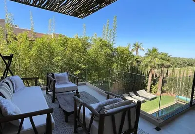a patio with chairs and a table and a glass door at Villa youssef in Oulad Tayeb
