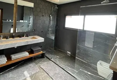a bathroom with a glass shower and a sink at Villa youssef in Oulad Tayeb