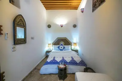 a bedroom with a bed and a mirror in a room at Dar Nana fes in Fès