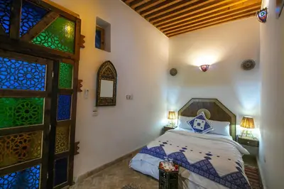 a bedroom with a bed next to a door at Dar Nana fes in Fès