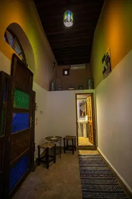 a room with a door and a table and chairs at Dar Nana fes in Fès