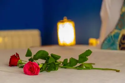 a red rose on a table with a candle at Riad Tahra & Spa in Fès