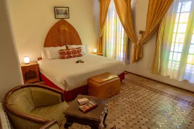 a bedroom with a bed and a chair in a room at Riad Tahra & Spa in Fès