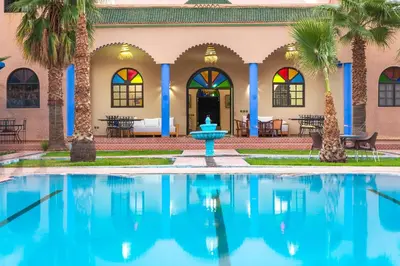 a pool in front of a house with a fountain at Riad Qodwa in Fourou