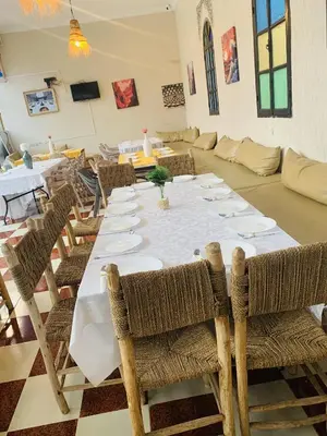 a dining room with a long table and chairs at Riad Qodwa in Fourou