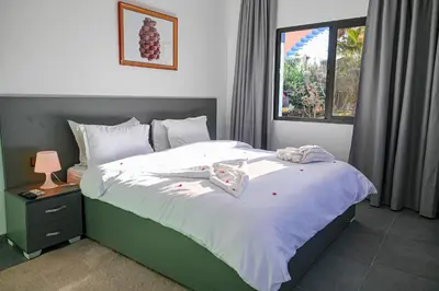 a bedroom with a bed with white sheets and a window at Riad Qodwa in Fourou