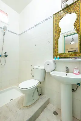 a bathroom with a toilet and a sink and a mirror at Riad Qodwa in Fourou