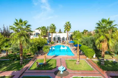 an aerial view of a resort with a swimming pool and palm trees at Riad Qodwa in Fourou