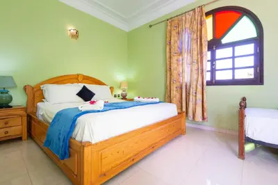 a bedroom with a bed with two dolls on it at Riad Qodwa in Fourou