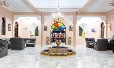 a lobby with a fountain in the middle of a room at Riad Qodwa in Fourou