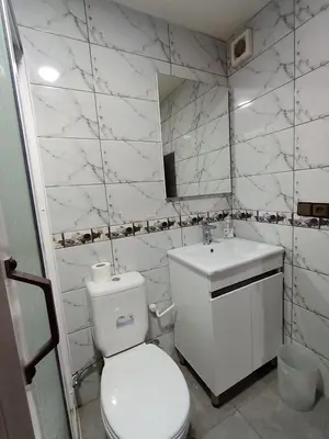 a white bathroom with a toilet and a sink at résidence sara in Fès