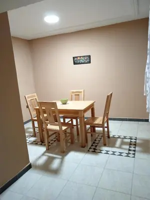 a dining room with a wooden table and chairs at résidence sara in Fès