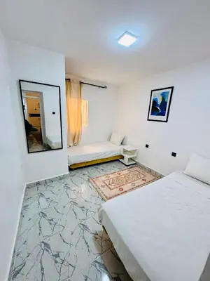 a white room with a bed and a mirror at Maison N 20 in Oulad Akkou