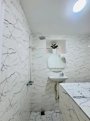 a white bathroom with a sink and a shower at Maison N 20 in Oulad Akkou