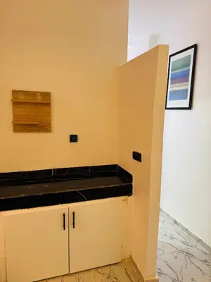 a kitchen with yellow walls and a black counter top at Maison N 20 in Oulad Akkou