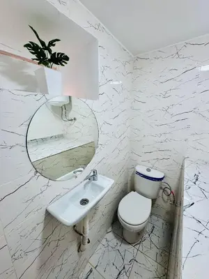 a white bathroom with a toilet and a sink at Maison N 20 in Oulad Akkou