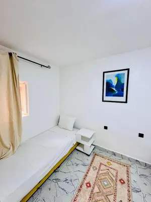 a white room with a bed and a rug at Maison N 20 in Oulad Akkou