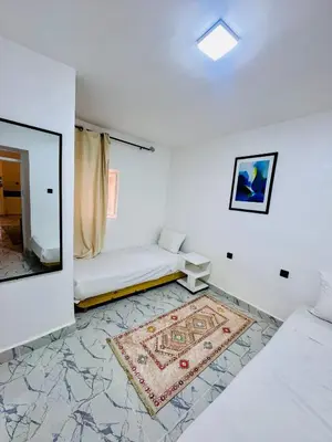 a white room with a couch and a rug at Maison N 20 in Oulad Akkou